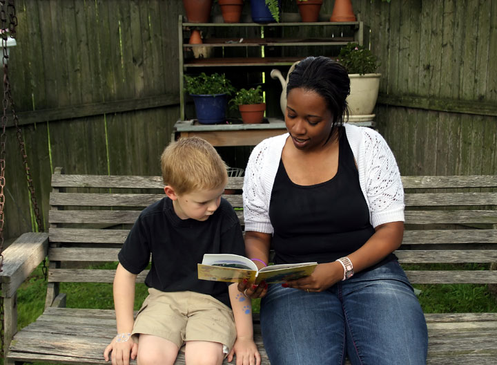 Woman volunteering to read a book to a young boy