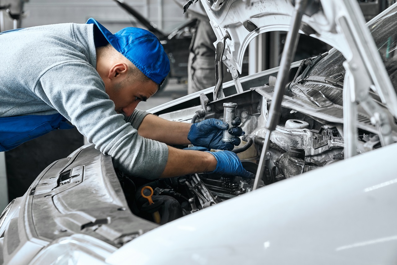 mechanic fixing car under the hood