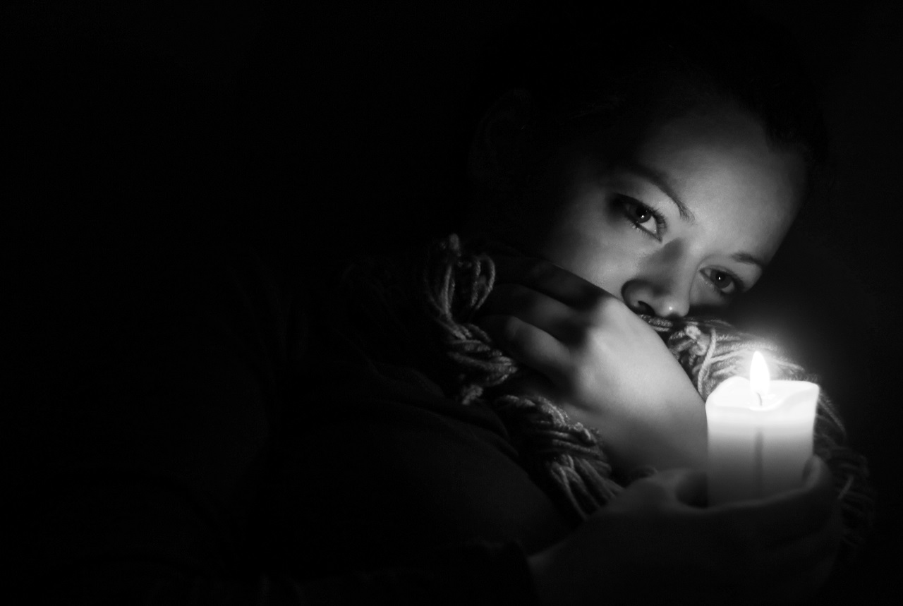 woman sitting in the dark with a candle