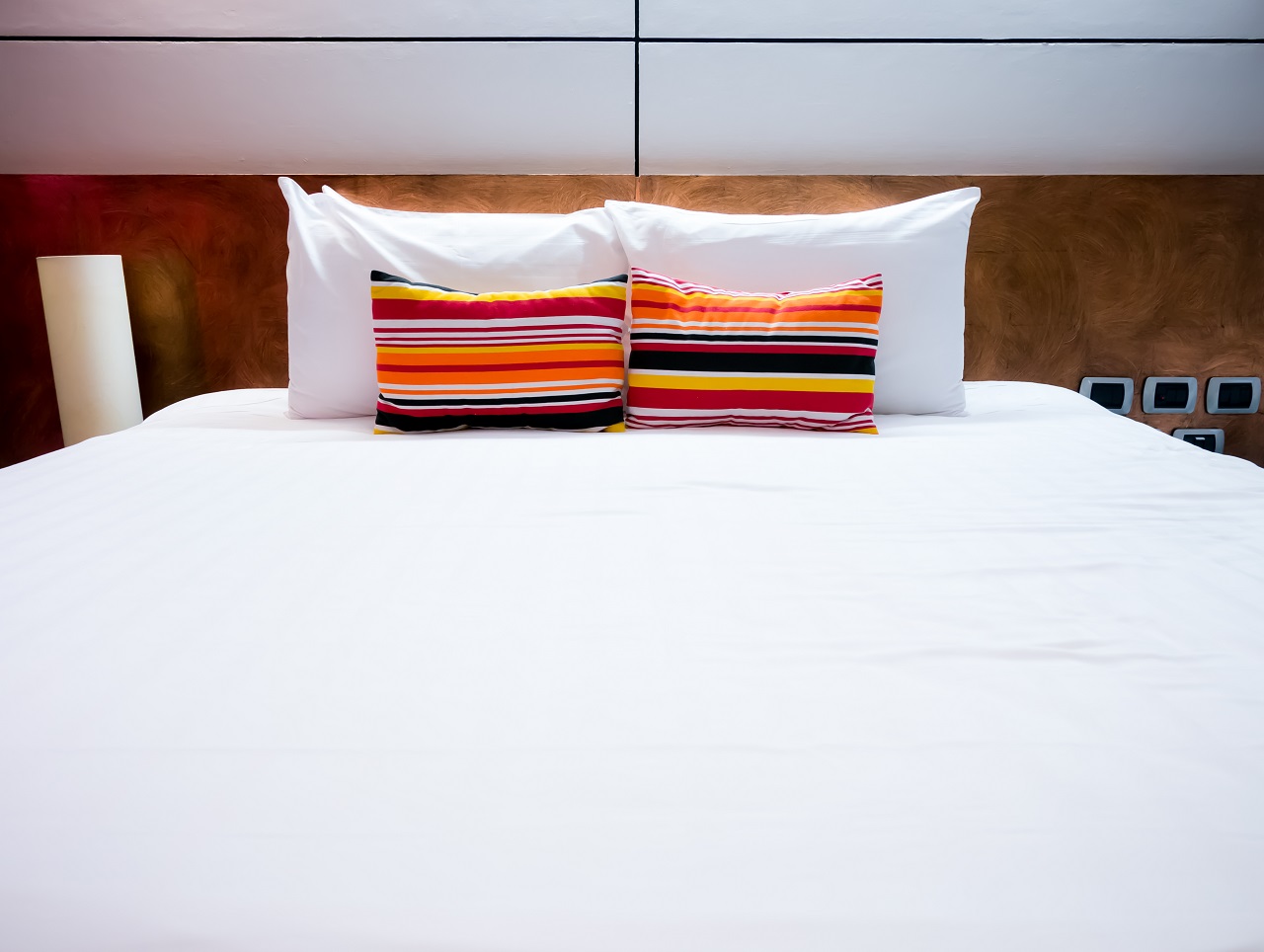 hotel room bed with colorful pillows