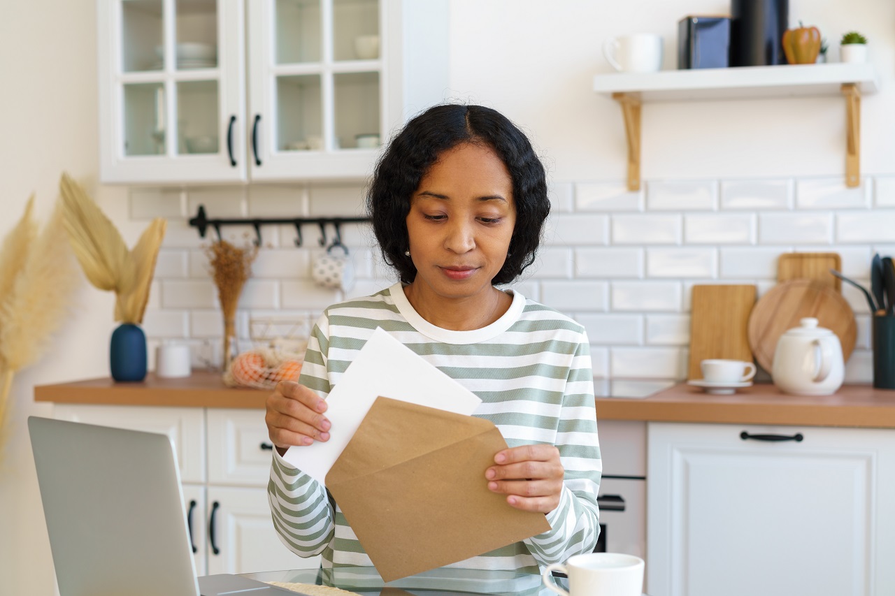 woman pulling her utility bill out of an envelope