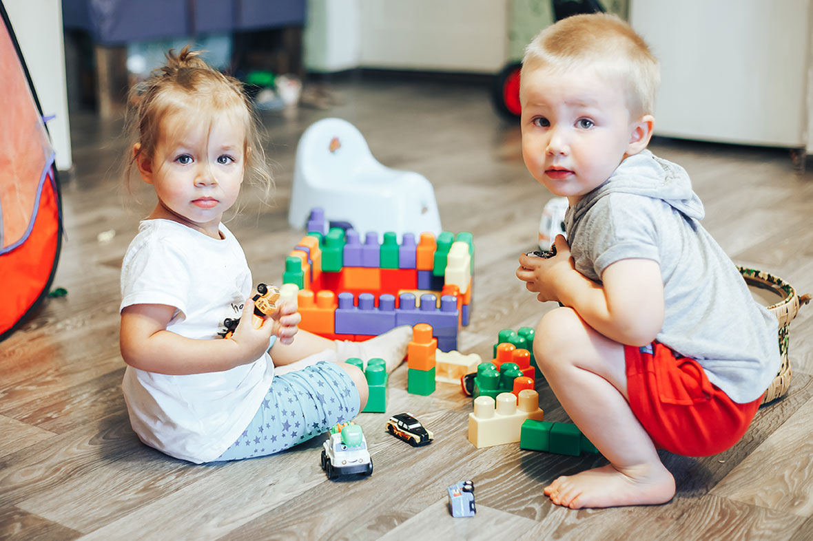 A small boy and girl playing with blocks
